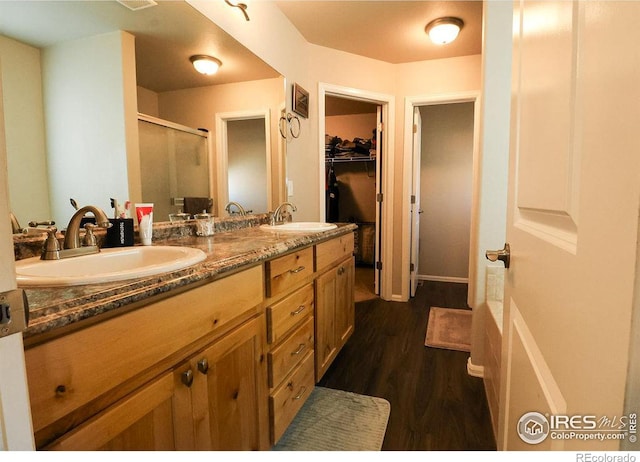 bathroom featuring hardwood / wood-style floors, vanity, and a shower with shower door