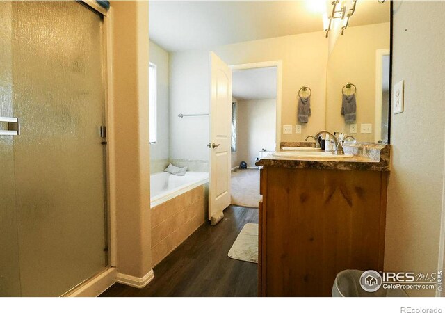 bathroom featuring wood-type flooring, vanity, and shower with separate bathtub