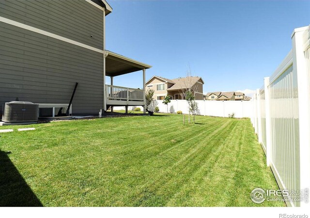 view of yard with central AC unit and a deck