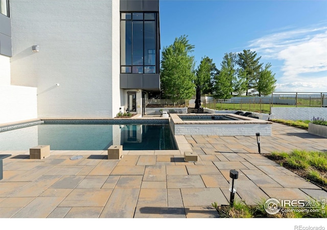 view of swimming pool with a patio area and an in ground hot tub