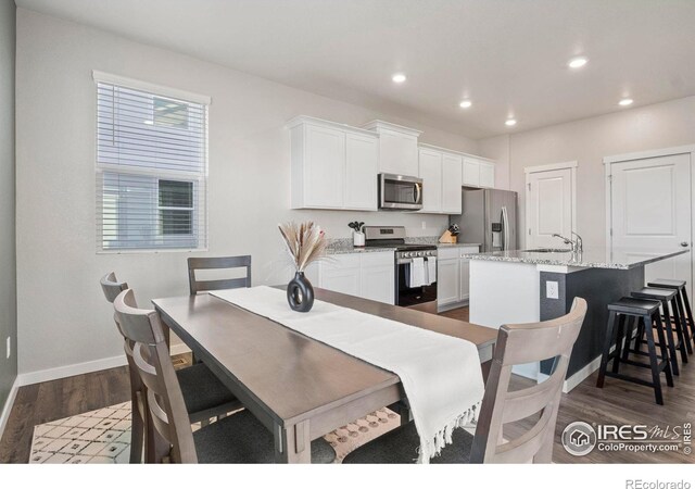 dining room featuring sink and dark hardwood / wood-style floors