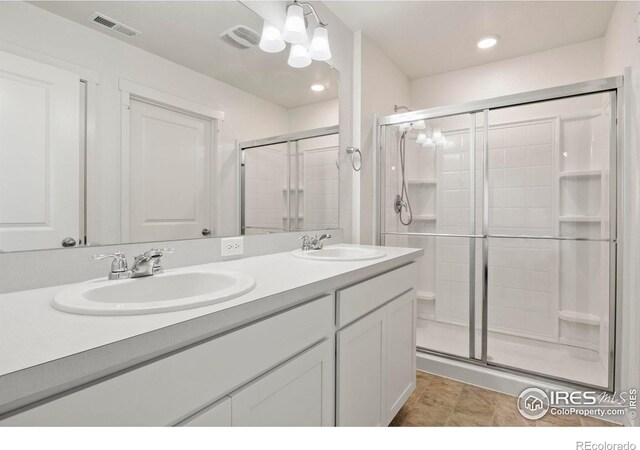 bathroom with tile patterned flooring, vanity, and a shower with shower door