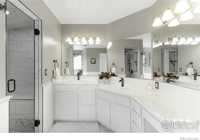 bathroom with tile patterned flooring, vanity, and an enclosed shower