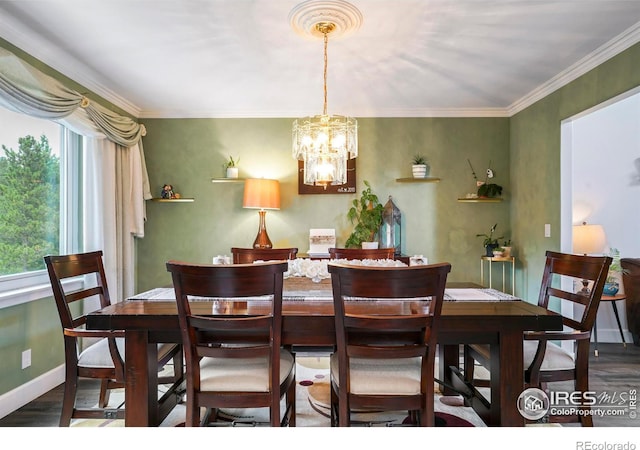 dining space with dark hardwood / wood-style floors, crown molding, and an inviting chandelier