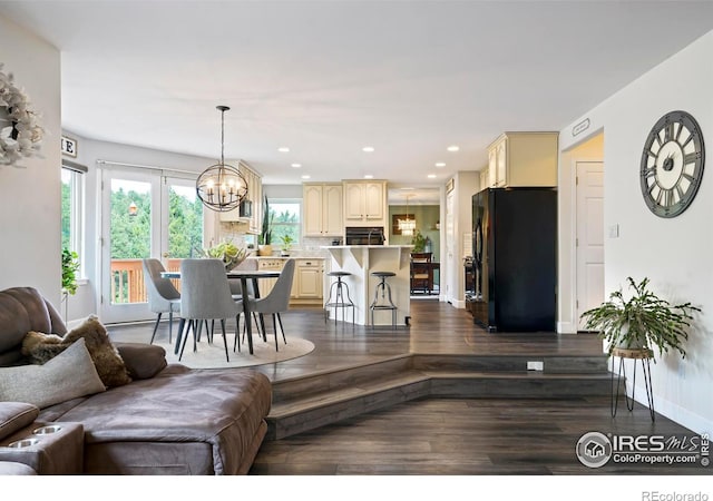 living room with dark hardwood / wood-style flooring and a chandelier