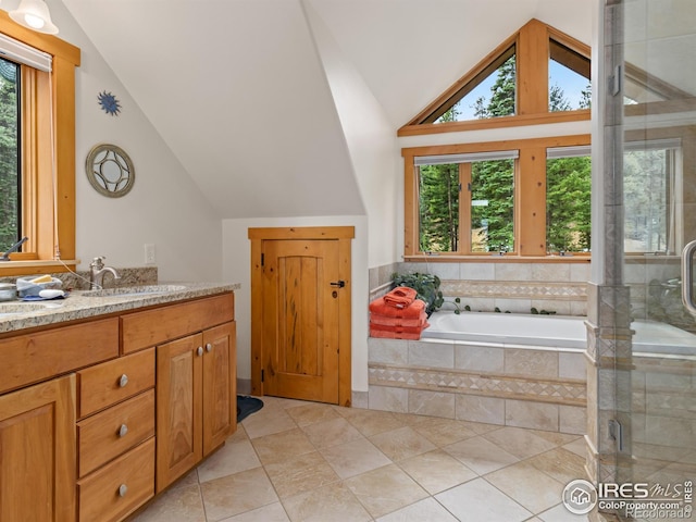 bathroom with vaulted ceiling, plenty of natural light, vanity, a shower stall, and a garden tub