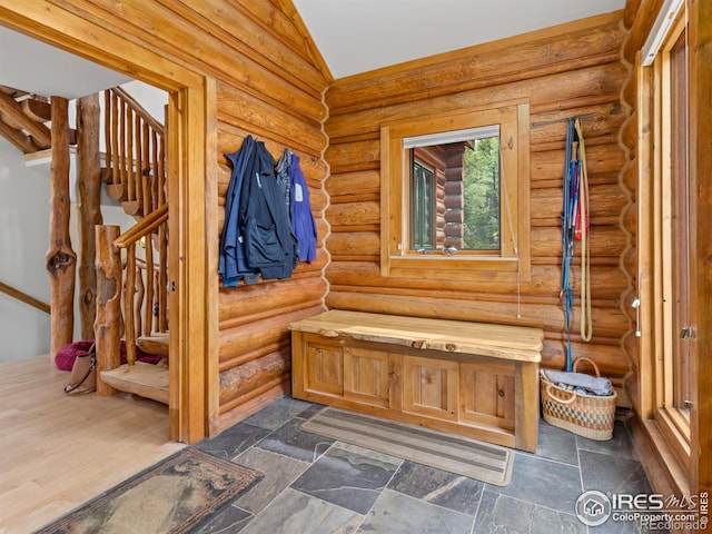 mudroom with dark hardwood / wood-style flooring, log walls, and vaulted ceiling