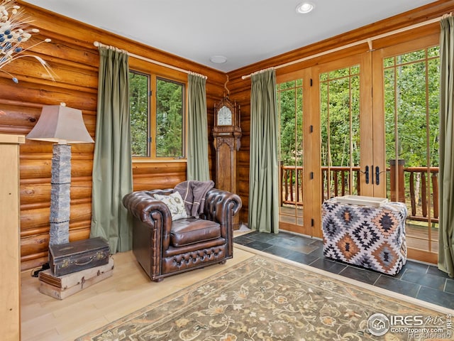 sitting room featuring hardwood / wood-style flooring, log walls, and french doors