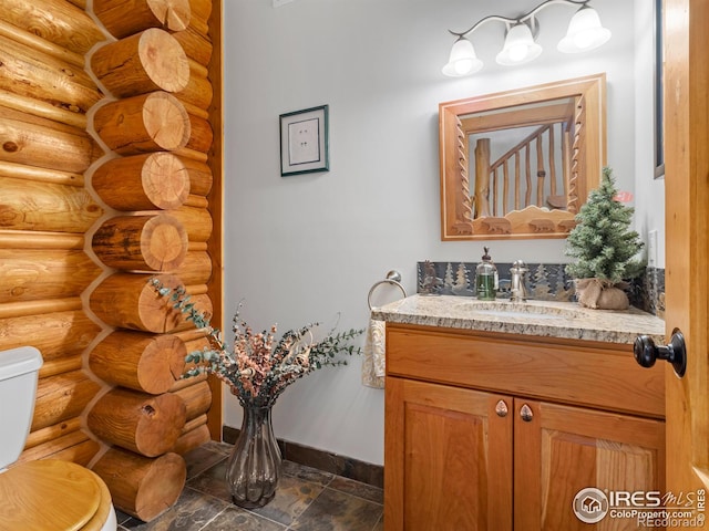 half bath featuring log walls, toilet, baseboards, and vanity