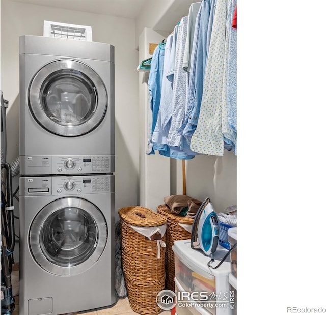 laundry room with tile patterned floors and stacked washer and clothes dryer