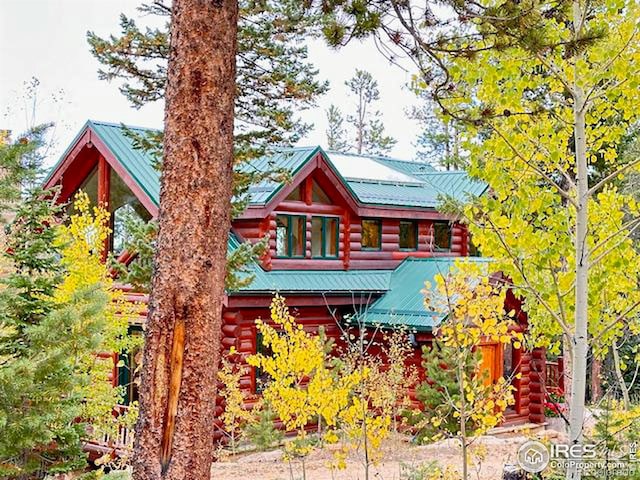 view of front facade featuring log siding and metal roof