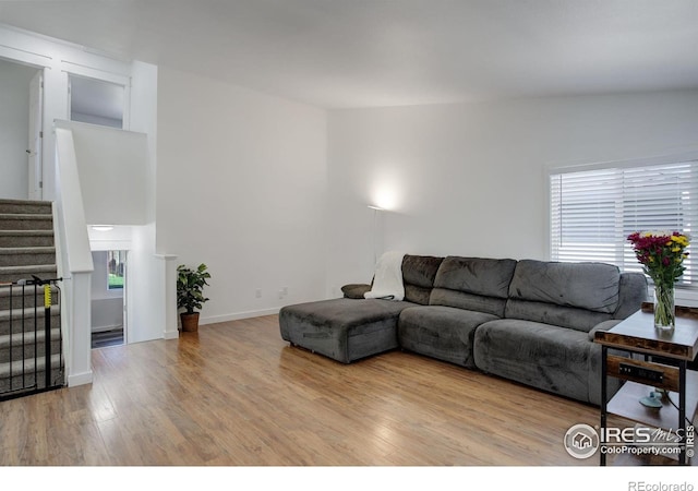 living room with light hardwood / wood-style flooring and lofted ceiling