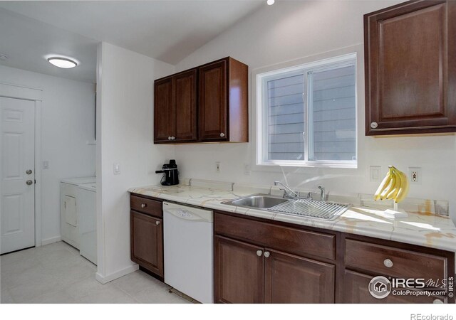 kitchen with dark brown cabinets, white dishwasher, sink, and washing machine and dryer