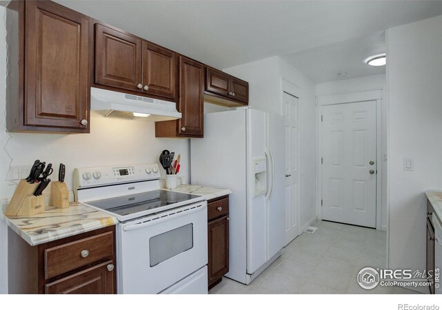 kitchen featuring white appliances and dark brown cabinetry