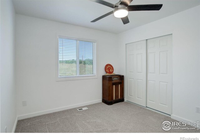 bedroom with ceiling fan, a closet, and light carpet