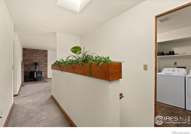 corridor featuring washing machine and clothes dryer, carpet flooring, and a skylight