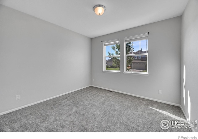 spare room with carpet and baseboards