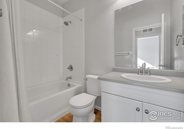 full bathroom with toilet, wood finished floors, vanity, visible vents, and tub / shower combination