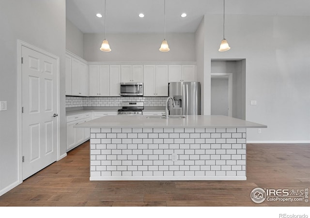 kitchen featuring a sink, appliances with stainless steel finishes, white cabinets, and light countertops