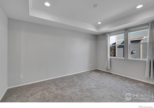 spare room with ornamental molding, carpet floors, a tray ceiling, and recessed lighting