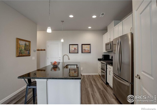 kitchen with white cabinets, appliances with stainless steel finishes, light hardwood / wood-style floors, and sink