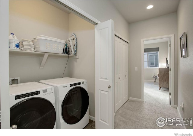 clothes washing area with light colored carpet and washer and clothes dryer