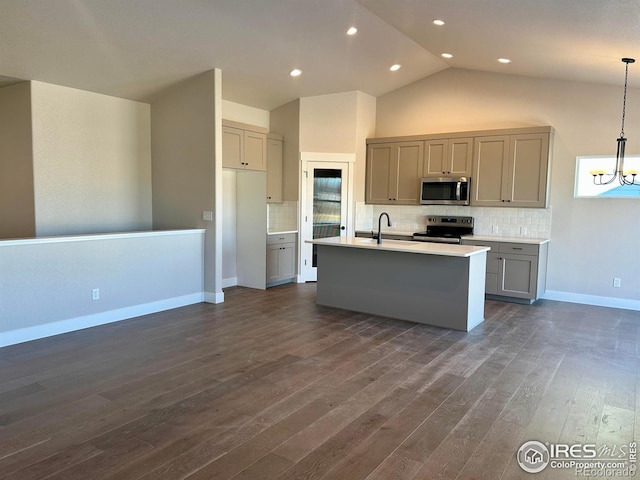 kitchen featuring pendant lighting, appliances with stainless steel finishes, gray cabinets, and an island with sink