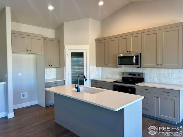 kitchen featuring sink, a kitchen island with sink, decorative backsplash, lofted ceiling, and stainless steel appliances