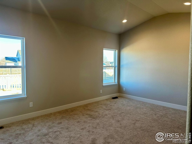 empty room featuring light colored carpet and lofted ceiling