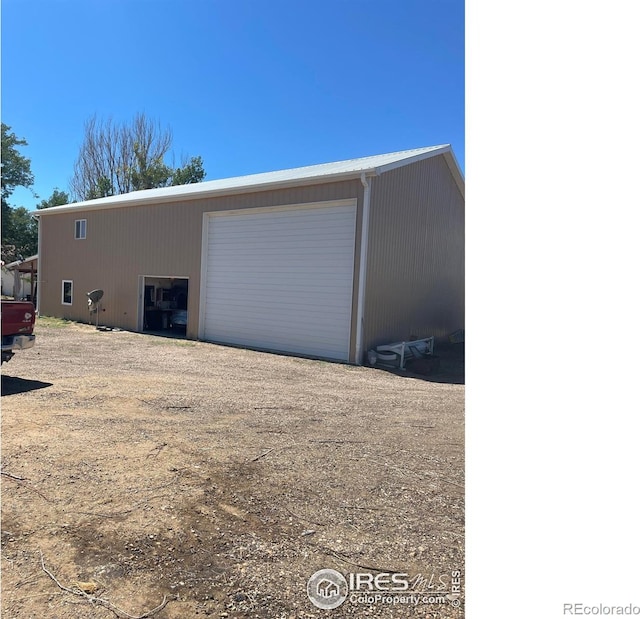 detached garage with dirt driveway