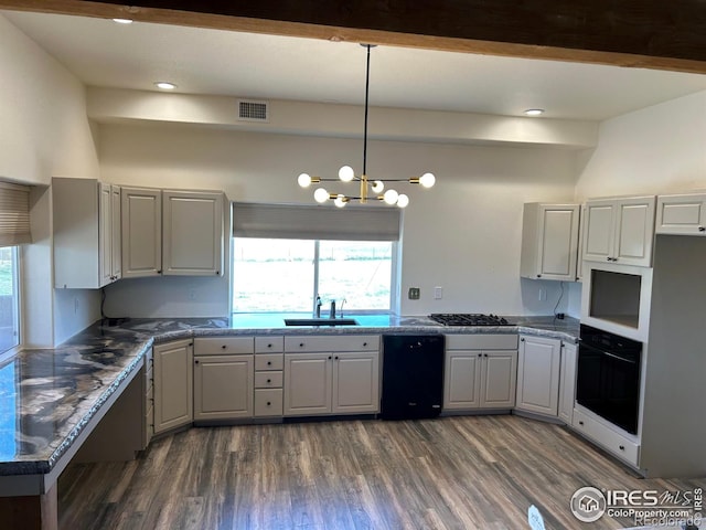 kitchen featuring a sink, visible vents, black appliances, plenty of natural light, and dark wood finished floors