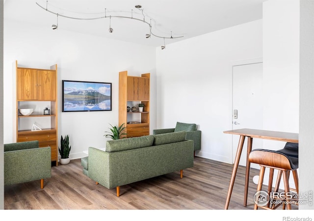 living room with a high ceiling, baseboards, and wood finished floors