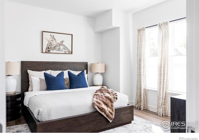 bedroom with multiple windows and wood finished floors