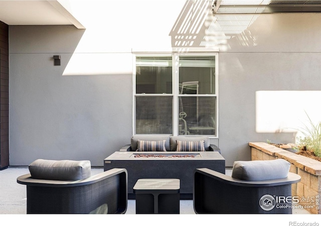 view of patio with an outdoor living space with a fire pit