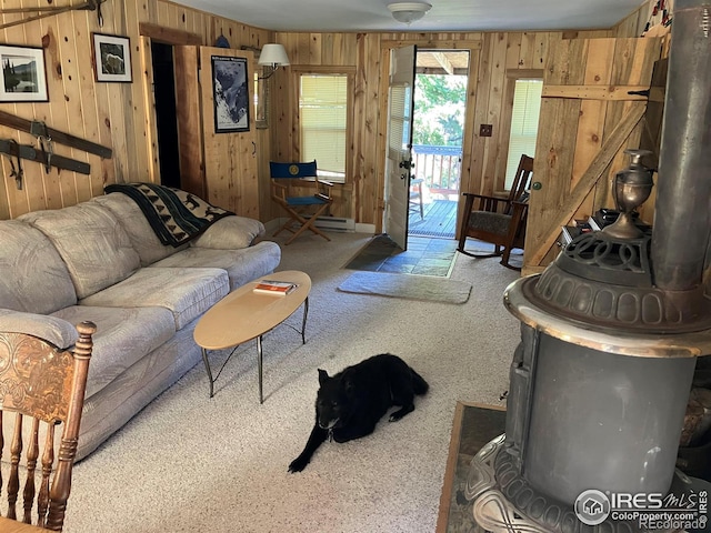 living room featuring carpet flooring, a wood stove, and wooden walls