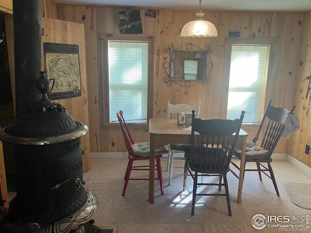 dining area featuring carpet and wood walls