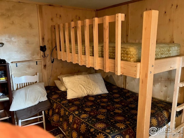 bedroom featuring wooden walls