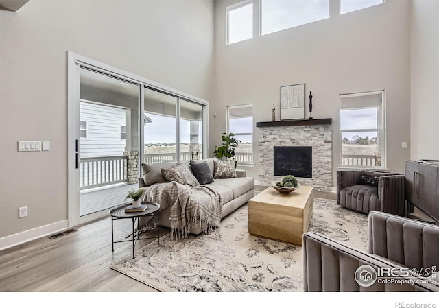 3140 Newfound Lake Rd, Berthoud, CO 80513 - living room featuring a stone fireplace, visible vents, wood finished floors, and plenty of natural light