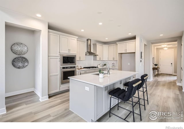 3140 Newfound Lake Rd, Berthoud, CO 80513 - kitchen with light countertops, a sink, wall chimney exhaust hood, appliances with stainless steel finishes, and light wood-style flooring