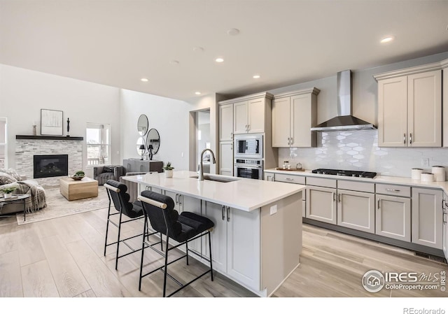3140 Newfound Lake Rd, Berthoud, CO 80513 - kitchen featuring backsplash, a sink, a breakfast bar area, stainless steel appliances, and wall chimney range hood