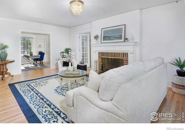 living room featuring hardwood / wood-style flooring, a fireplace, and an inviting chandelier