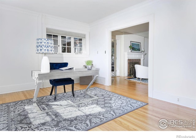 interior space with crown molding, hardwood / wood-style flooring, and a brick fireplace