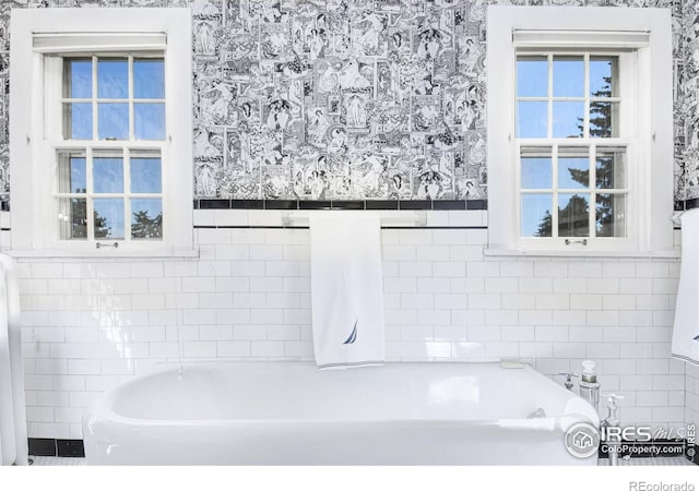 bathroom with tile walls and a washtub