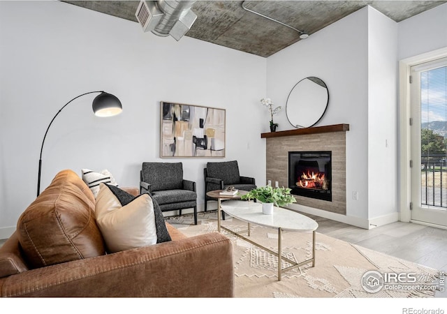 living room featuring a fireplace, wood finished floors, and baseboards