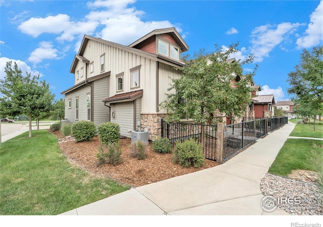 exterior space featuring cooling unit, fence, a yard, stone siding, and board and batten siding