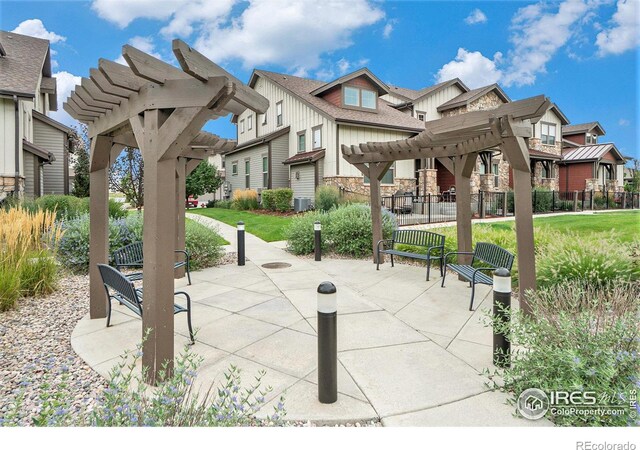 view of home's community featuring a lawn, a patio, and a pergola