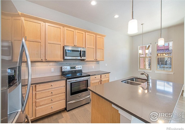 kitchen featuring pendant lighting, backsplash, appliances with stainless steel finishes, light hardwood / wood-style floors, and sink