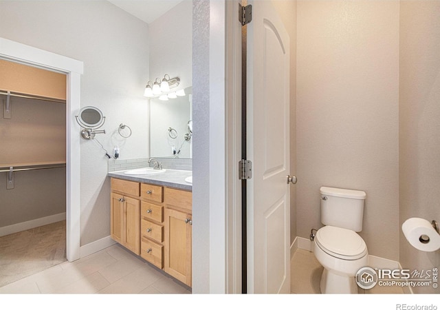 bathroom featuring tile patterned flooring, toilet, and vanity