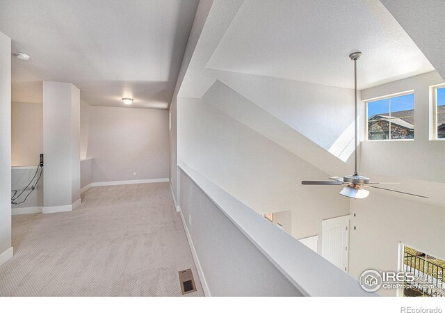 corridor featuring light carpet and a textured ceiling