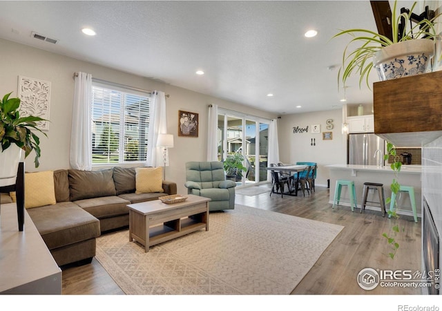 living room with light hardwood / wood-style floors, a textured ceiling, and sink